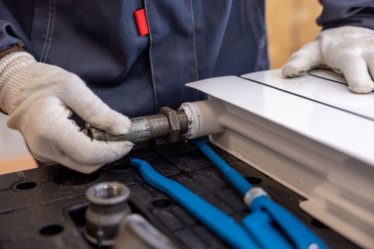 our-mission Close-up of a plumber installing a radiator pipe using specialized tools.